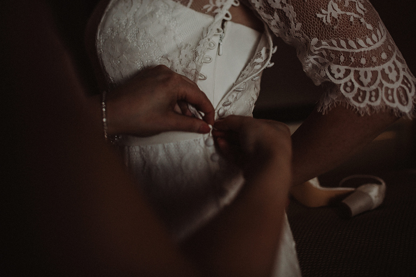 getting ready in the shelbourne hotel bridesmaid is doing buttons on the dress