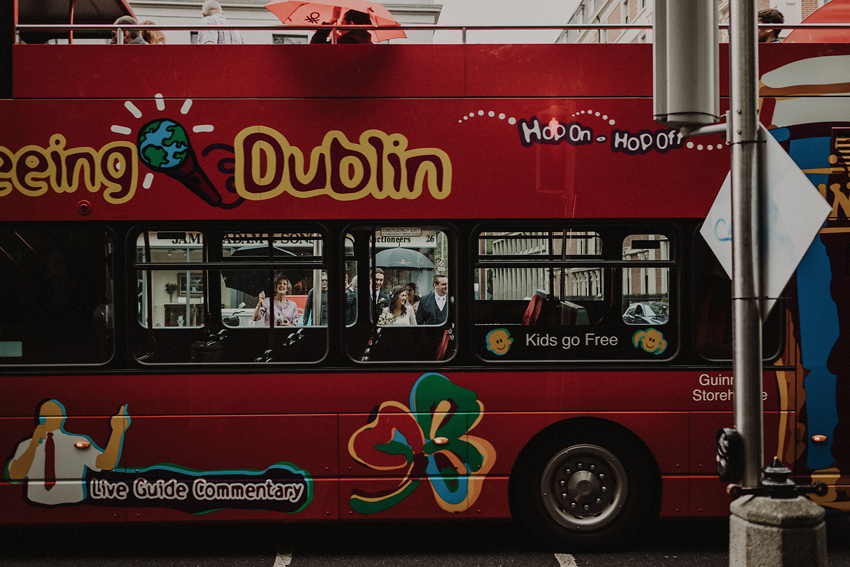 cool shot of bride and groom through the dublin sightseeing bus