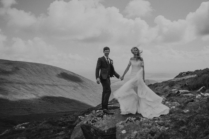 epic photo on the mountain with movement in the wedding dress