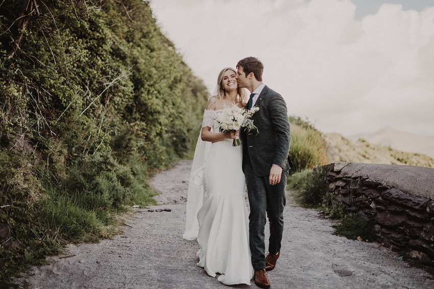 bride and groom walking down the beach 